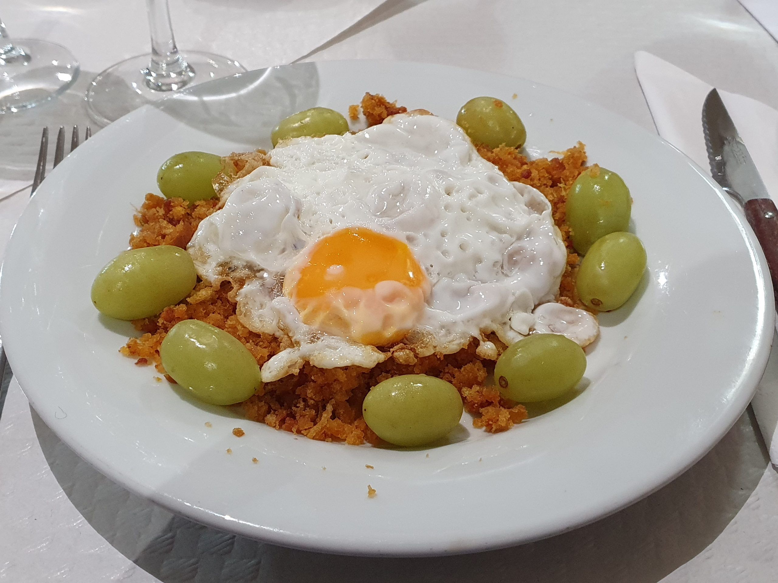 Migas con huevo frito y uva