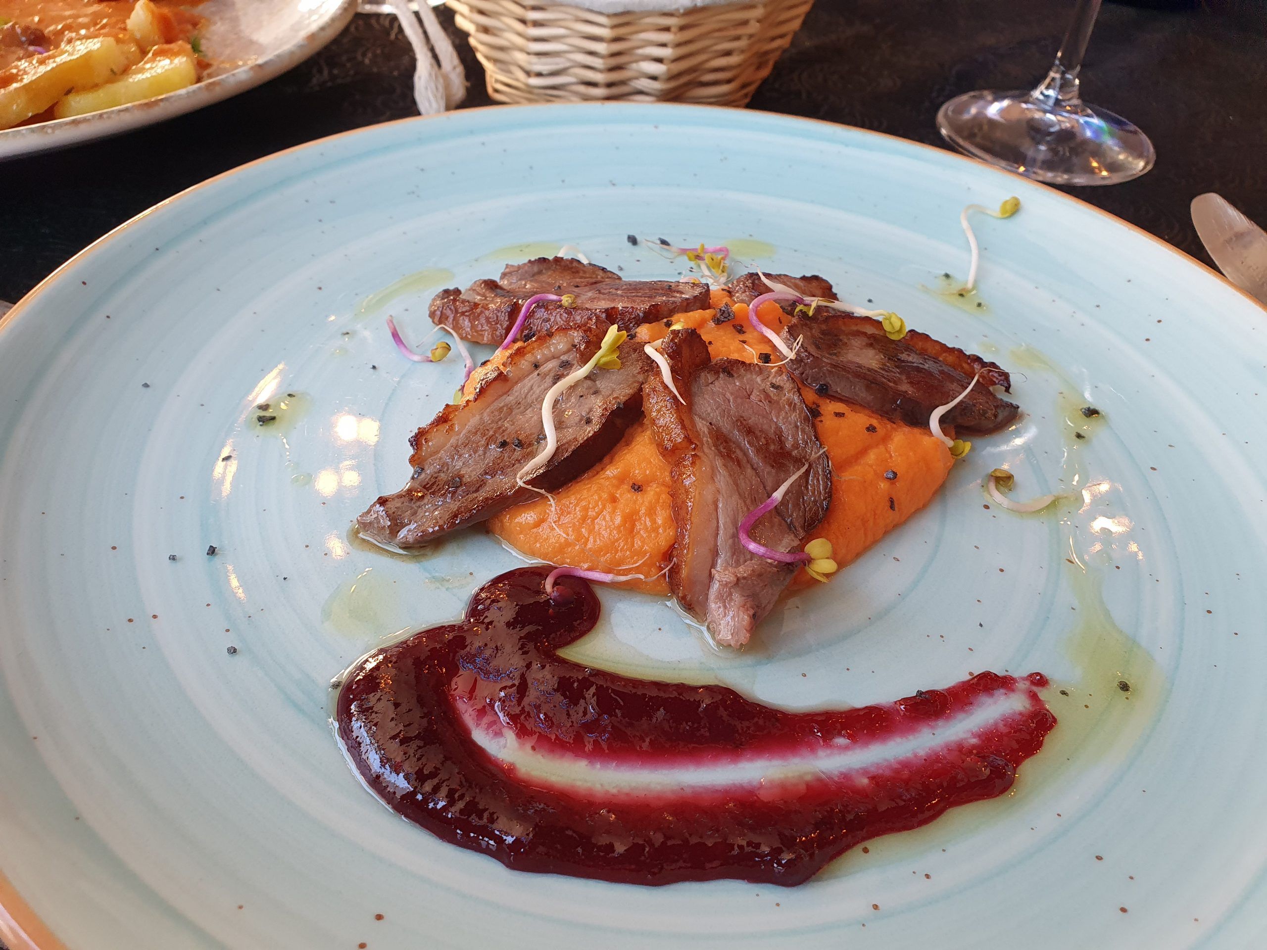 Magret de pato laminado con salsa de frutos del bosque y parmentier de boniato glaseado
